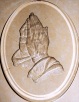oval with praying hands at the center
